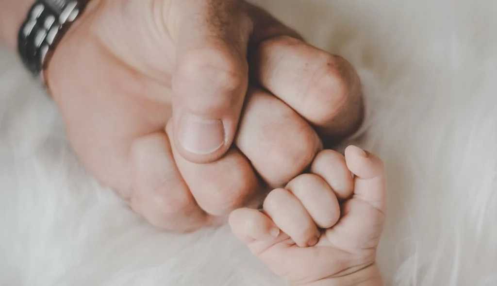 A new father bumping fists with a baby