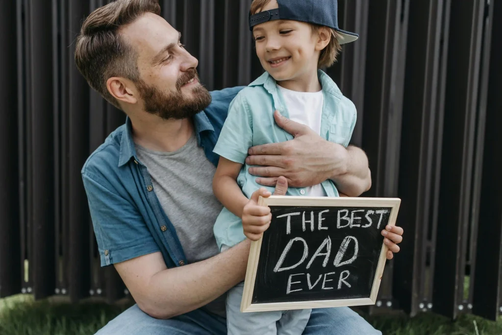 a dad and a son with a board saying the best dad ever